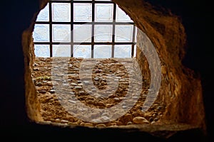 old window in the building with cross bars on the window to avoid unwelcome intrusion