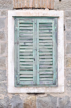 Old window with closed shutters on an old house