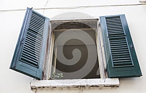 Old window with closed shutters on the window sill on the stone wall. Italian Village