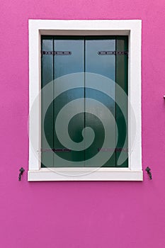 Old window with dark green shutters on pink (fucsia) wall photo
