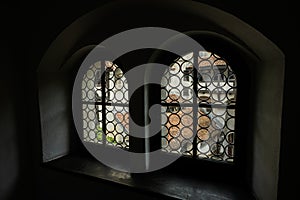 Old window in the dark room of castle, view from the inside of the building