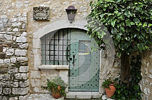 Old window and door of medieval house under tree
