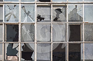 Old window frame of industrial building with broken glass