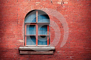 Old window frame with steel bars shutter exterior as prison or residential apartment front view. Weathered house wall