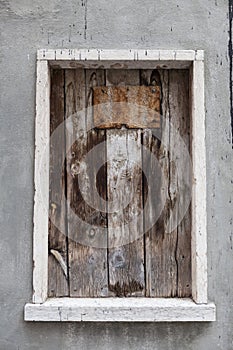 Old window hammered wooden planks on a stone wall, an abandoned farmhouse Provence.