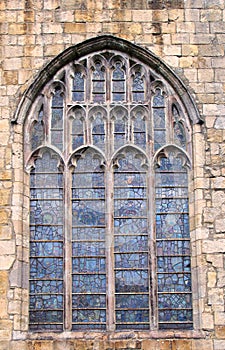 Old window on the historic medieval cartmel priory in cumbria now the parish church of st micheal and mary