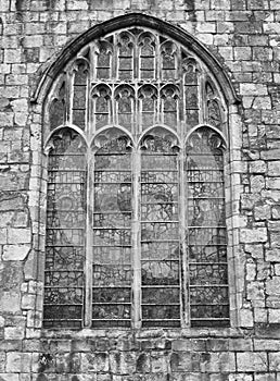 Old window on the historic medieval cartmel priory in cumbria now the parish church of st micheal and mary