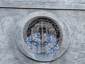 Old window with little vitrage design in old building. Landscape architecture.