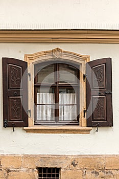 Old window made of stone and wood with brown shutters