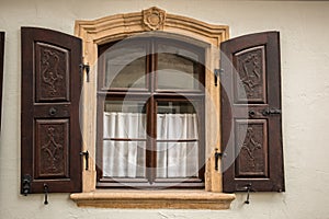 Old window made of stone and wood with brown shutters