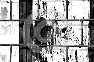 Old window painted white paint behind a rusty bars, black and white