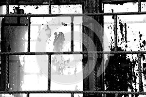 Old window painted white paint behind a rusty bars, black and white