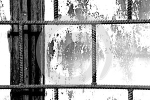 Old window painted white paint behind a rusty bars, black and white