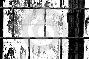 Old window painted white paint behind a rusty bars, black and white