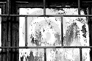 Old window painted white paint behind a rusty bars, black and white