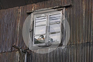 Old window and rusty corrugated wall