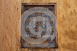 Old window with rusty metal bars in one of the buildings in medina of Meknes, Morocco