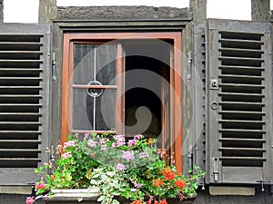 Old window with shutters and flower arrangements