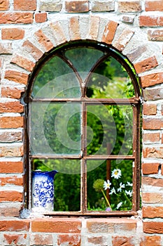 Old window in the stone wall in the garden