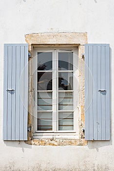 Old window with wooden gray painted shutters