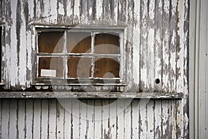 Old window of wooden house painted peeling white paint