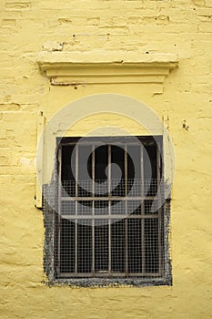 The old window on yellow wall