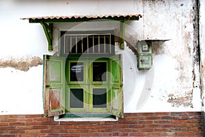 Old windows and an electric meter on a wall in kotagede