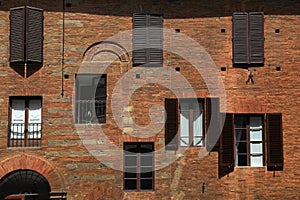 Old windows with shutters on medieval red brick textured wall, I