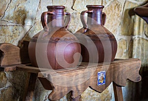 Old wine barrels in a wine cellar. Stacked up wine bottles in the cellar, dusty but tasty.