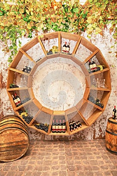 Old wine barrels, grapes, casks and bottles in wine-cellar