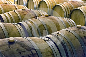 Old wine barrels in rows inside a wine cellar