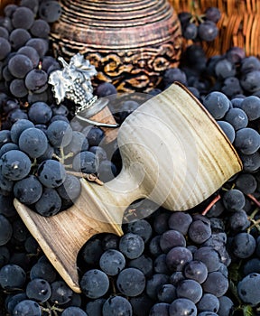 Old wine pitcher and clay glass, winemaking emblem and a cork.