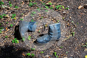 Old winter men's boots with locks lie on the ground.