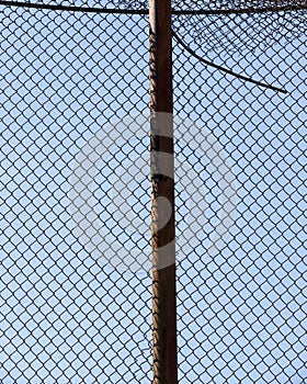 old wire fence made of thin wire against the blue sky