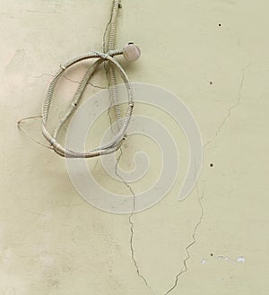 Old wire hanging on the wall twisted