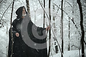 Old wise man in dark forest