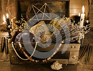 Old witch box with tarot cards, healing herbs and crystal ball on the table