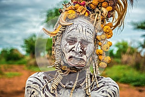 Old woman from the african tribe Mursi in her village