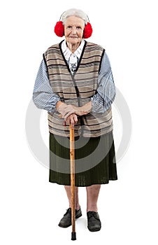 Old woman with a cane wearing faux fur ear muffs