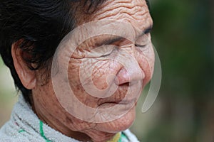 Old woman closes one's eyes