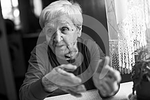 An old woman during a conversation. Black and white photo.