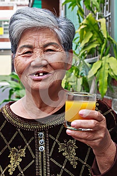 Old woman drinking juice