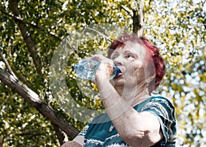 Old woman drinking mineral water