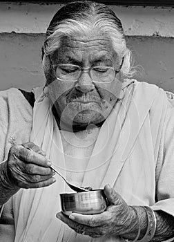 An old woman eating supper