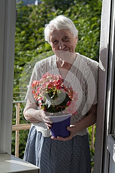 old woman with flowers on the balcony