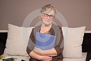 Old woman with a folder holding hands