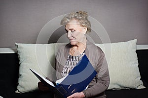 Old woman with a folder holding hands