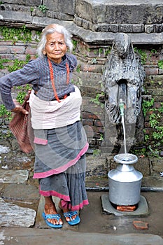 Old woman getting water