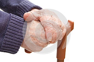 Old woman hand leans on walking stick