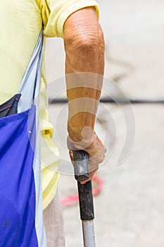 Old woman hand leans on walking stick, close-up